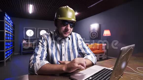 年轻留胡子的男性戴上太阳镜和绿色安全施工头盔视频的预览图