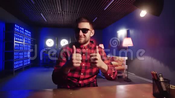 有魅力的男性坐在办公桌前在房间里竖起大拇指用照明冷却器视频的预览图