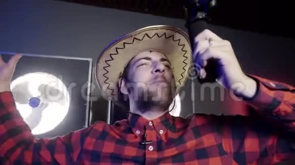 好看的灰眼大胡子男人带着墨西哥帽子拿着麦克风唱歌视频的预览图