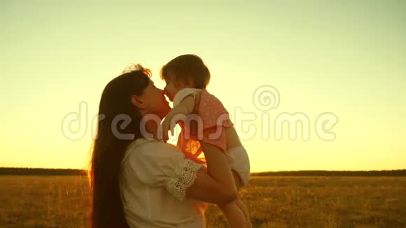 一个幸福的家庭妈妈在夏天和她的小女儿在公园里玩日落慢动作快乐的童年视频的预览图