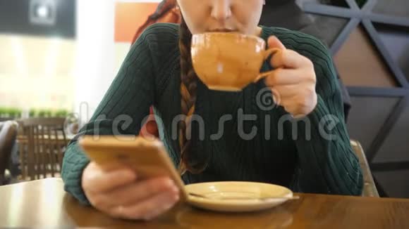 手拿电话喝咖啡的无名女孩视频的预览图