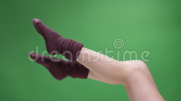 特写侧景拍摄女青少年腿在可爱的短红袜子嬉戏移动与后轮孤立在绿色视频的预览图