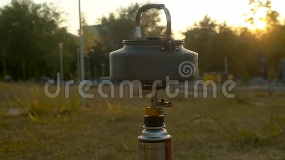 在公园的露营炉上加热水壶视频的预览图