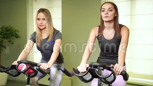 在健身房或健身俱乐部锻炼腿的年轻女性视频的预览图