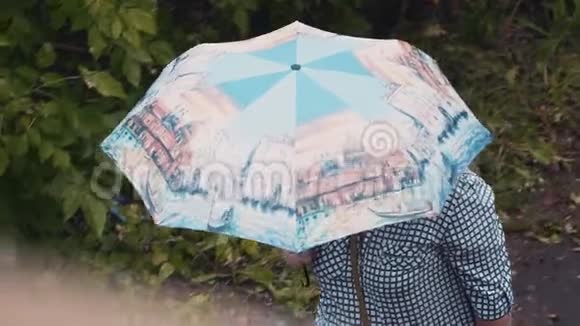 一个女人躲在伞下从上面看到的慢动作录像坏天气视频的预览图