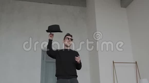 迷人的帅哥戴着时尚的黑色太阳镜戴着男人的帽子跳舞移动他的身体在索引上扭曲一顶帽子视频的预览图