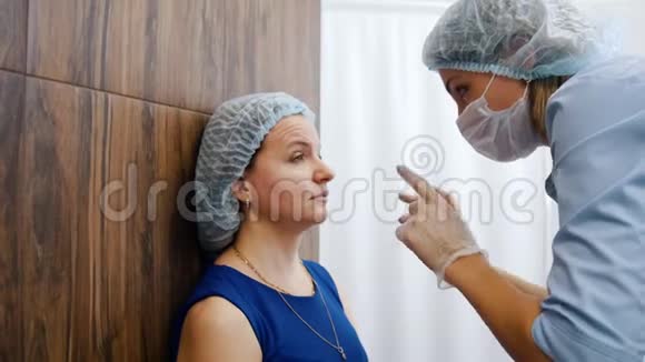 美容诊所的女人在女人脸上画素描专家视频的预览图