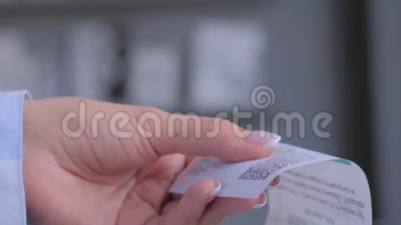 女士使用智能手机扫描现金商店收据纸上的QR码视频的预览图