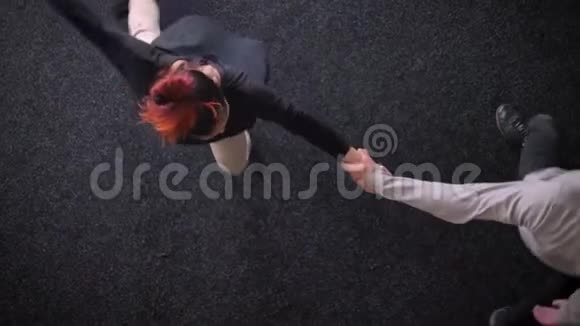 在黑色背景下一个性感舞蹈的姜女和黑头男的顶级镜头视频的预览图