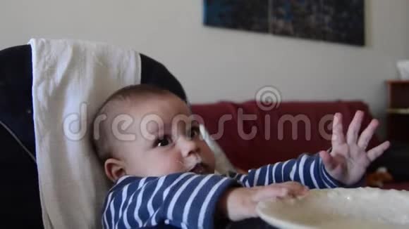 饥饿的婴儿等不及食物了妈妈在逗孩子却给他用勺子吃饭视频的预览图