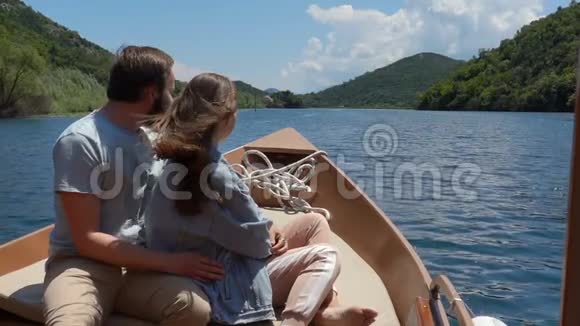 阳光明媚的一天一对夫妇在湖上乘摩托艇视频的预览图