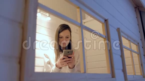 女人打电话留言坐在孩子玩的房子里妈妈躲着孩子视频的预览图