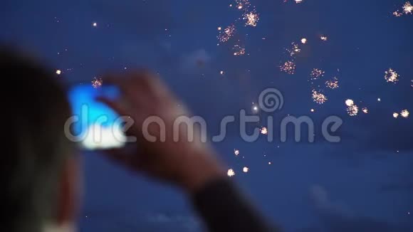 男人晚上用智能手机燃放烟花视频的预览图