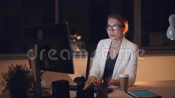 漂亮的年轻女秘书深夜在电脑上工作然后摘下眼镜揉着疲惫的眼睛视频的预览图