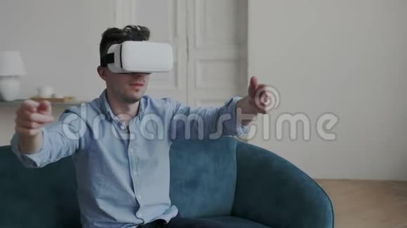英俊时尚的家伙探索和测试虚拟现实眼镜室内他在互动时移动手指视频的预览图