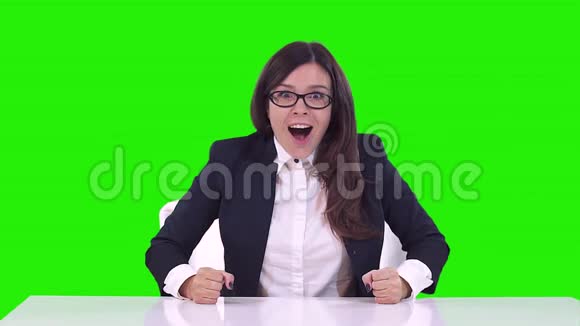 办公室里一个女人绿色背景的肖像戴眼镜的黑发女人在工作中高兴微笑跳舞视频的预览图