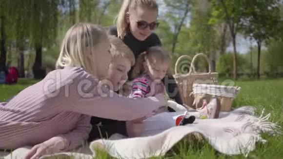 肖像家庭户外娱乐活动两位美丽的年轻母亲和他们的孩子在公园野餐一个男孩和一个视频的预览图