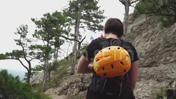 一位携带登山设备的旅行者女性在山区背景下漫步视频的预览图