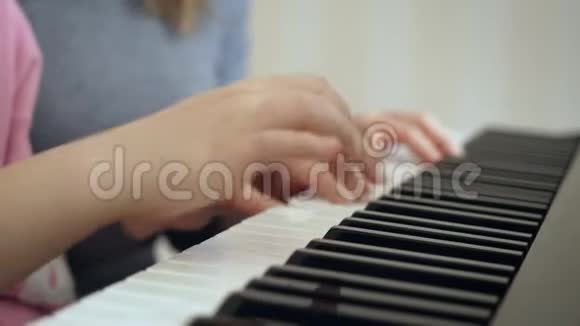 年轻的女人教小女孩弹钢琴视频的预览图