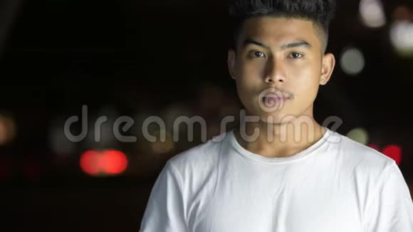 一张快乐的亚洲年轻人的脸在城市的街道上微笑视频的预览图