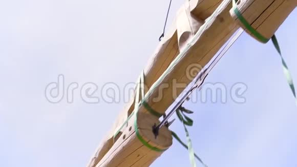 底部查看起重机机构吊装原木的蓝色多云天空背景剪辑带木材的起重机视频的预览图