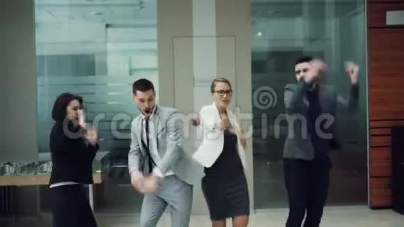 快乐的青年同事在办公室大厅跳舞一起玩得开心在公司聚会上放松千禧一代好视频的预览图