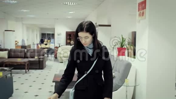 家具店里穿黑色外套的年轻女人选择家具视频的预览图