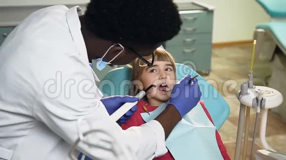 多莉拍摄的非洲男性牙医治疗小女孩的牙齿视频的预览图