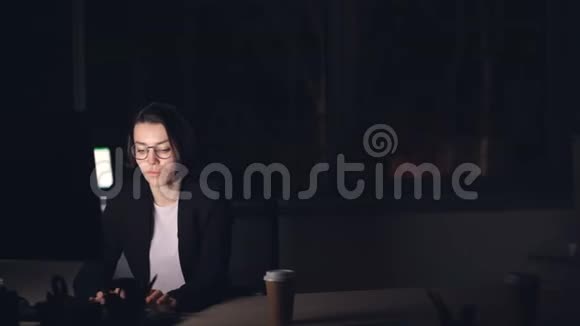 她的男经理来了正在和她说话她指着她说她很累黑发女郎正在深夜用电脑工作视频的预览图