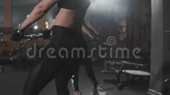 金发蹲在黑暗健身房的模拟器里健身女蹲加强腿部视频的预览图