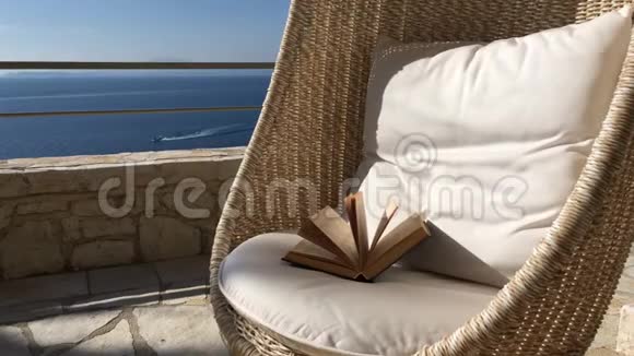阳光明媚的一天带海景的藤摇椅视频的预览图