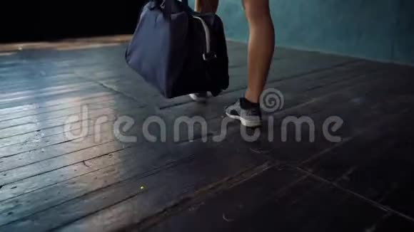 带蓝包的年轻健康女性腿进入健身俱乐部准备拳击训练视频的预览图