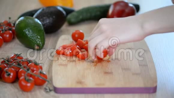 女人正在切樱桃西红柿作为木桌上的沙拉视频的预览图