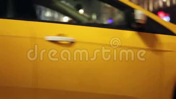 黄色的出租车在夜城的背景下在短暂停留后开始移动视频的预览图