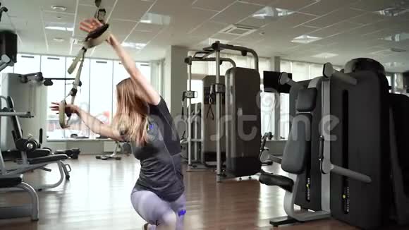 年轻女子在健身房使用健身带TRX进行锻炼视频的预览图