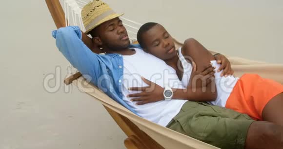 非裔美国人夫妇睡在海滩吊床上的景色视频的预览图