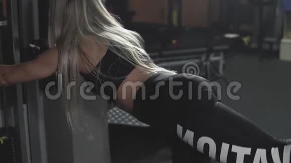 美丽的女人在黑暗的健身房锻炼腿部和臀部肌肉视频的预览图