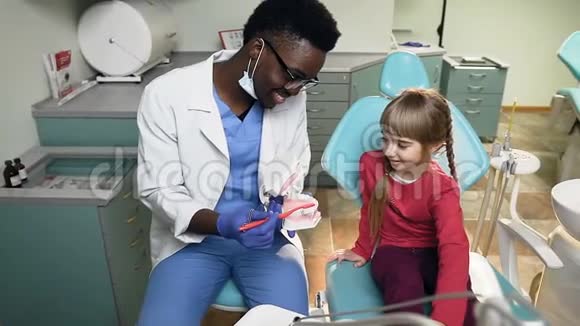 非洲牙医教小女病人如何在塑料模型上刷牙视频的预览图
