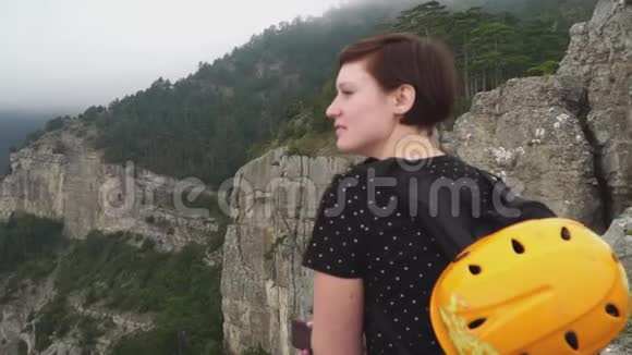 夏天坐在山顶上看风景的年轻女子视频的预览图