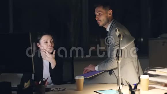 性格开朗的男女同事晚上在办公室里和电脑一起聊天视频的预览图