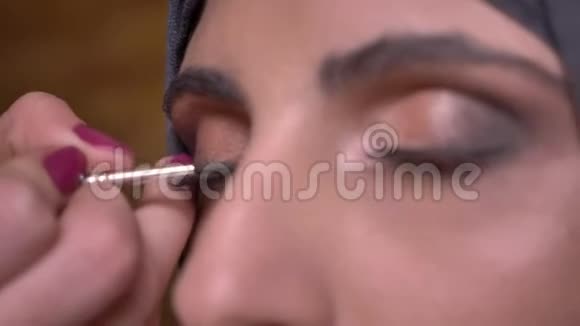 女性手画黑色箭头的肖像美丽的穆斯林女士在头巾上的眼睛在布里克肯墙背景视频的预览图