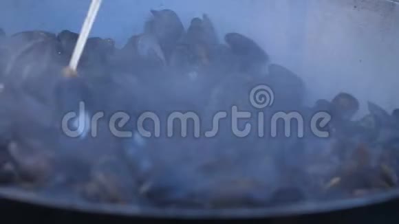 一个厨师在一个大锅里准备贻贝用来煮街上的食物视频的预览图