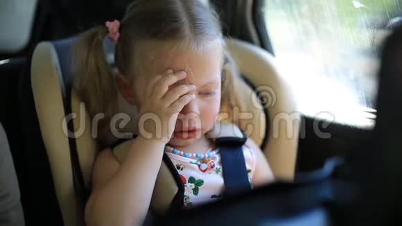 两岁的女孩坐在车里坐在孩子们车座上哭得很伤心视频的预览图