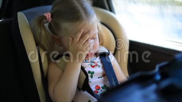 两岁的女孩坐在车里坐在孩子们车座上哭得很伤心视频的预览图
