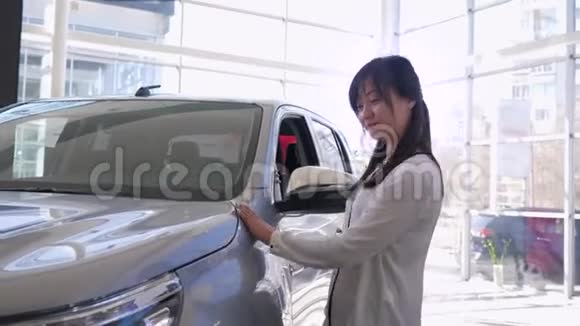 汽车经销商幸福汽车商店工人的肖像亚洲妇女高兴地拍拍汽车并显示新机器的钥匙视频的预览图
