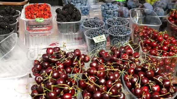 新鲜的不同浆果在塑料杯浆果和异国水果在集市或街头市场视频的预览图