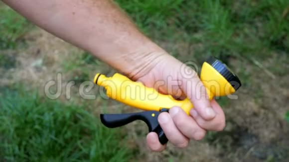 人类双手将黄色花园喷雾器插入新的绿色橡胶软管中视频的预览图