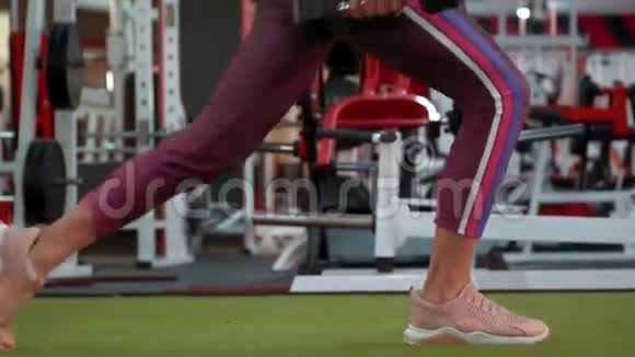 穿着运动服的漂亮运动健身女孩正在健身房做向前冲的运动视频的预览图