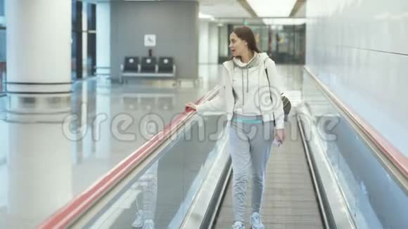 穿着运动服的年轻女子在机场的走道上视频的预览图