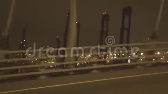 在经过海修港的夜间城市公路上从驾驶汽车上摇晃射击从车窗驾驶汽车到工业的视野视频的预览图